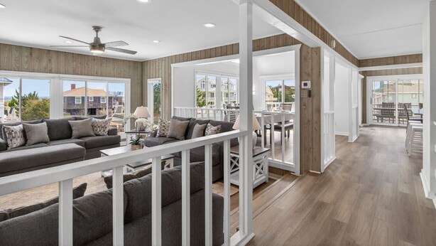 A spacious living area with a large sofa, a dining table, and a ceiling fan. - New! Luxe Sandbridge Beach, Pool, Hot Tub (Virginia Beach)
