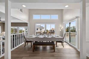 A dining area with a table set for four, large windows, and a view of the outside. - sandlkj;lkansd;lgna;sngljkn (Virginia Beach)