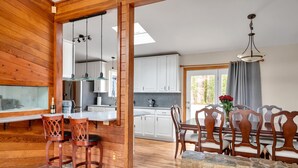 A wooden interior with a kitchen, dining area, and a stone table. - Unique Durham Cabin with Hot tub and close to Duke (Durham)