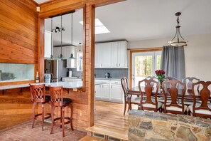 A wooden interior with a kitchen, dining area, and a stone table. - Unique Durham Cabin with Hot tub and close to Duke (Durham)