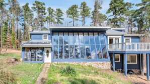 A two-story house with large windows, a stone foundation, and a deck. - Unique Durham Cabin with Hot tub and close to Duke (Durham)