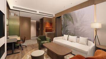 A modern hotel room with a sofa, armchair, coffee table, desk, and lamp.