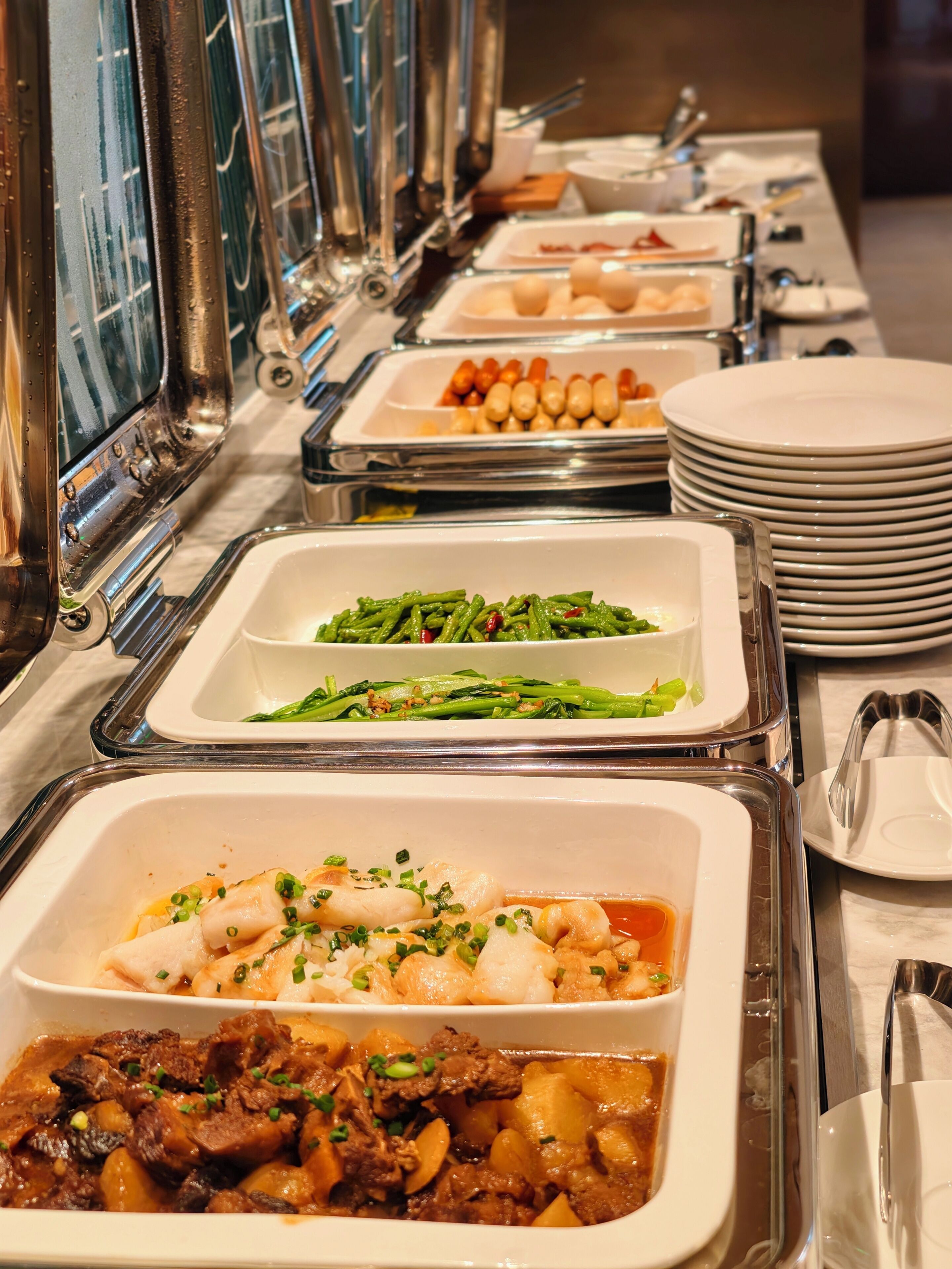 Un buffet proposant une variété de plats, notamment des fruits de mer, des légumes et de la viande.