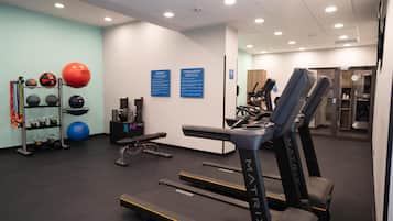 A gym with treadmills, exercise balls, and weightlifting equipment.