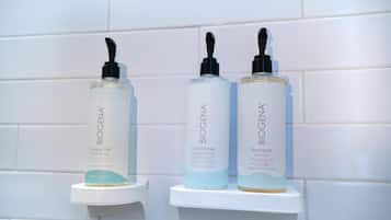 Tres productos de BiogenA sobre un estante blanco frente a una pared de azulejos blancos.