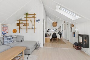A modern, open-plan living space with a loft area, a dining area, and a fireplace. - Lovely cottage – close to a beautiful beach (Vig)