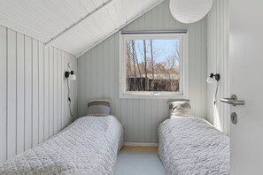 A bedroom with two beds, a window, and a door. - Lovely cottage close to a beautiful beach (Vig)