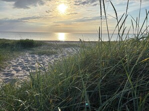 A beach with sand and grass in the foreground, and the ocean in the background. - Lovely cottage – close to a beautiful beach (Vig)