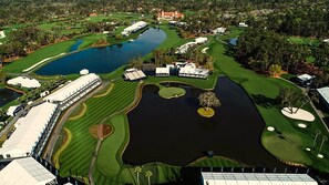 Un parcours de golf doté de plusieurs étangs, d’un club-house et entouré de verdure.