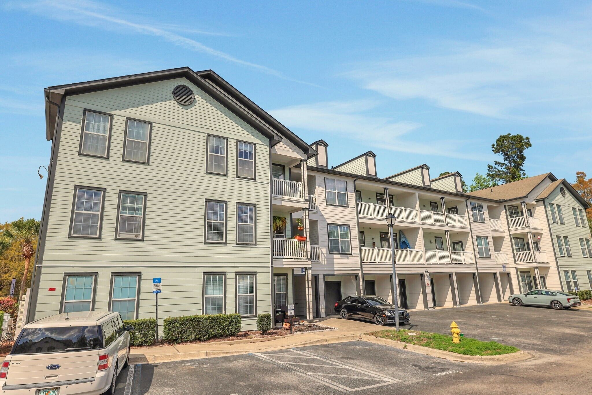 A multi-story hotel with a parking lot and a fire hydrant.