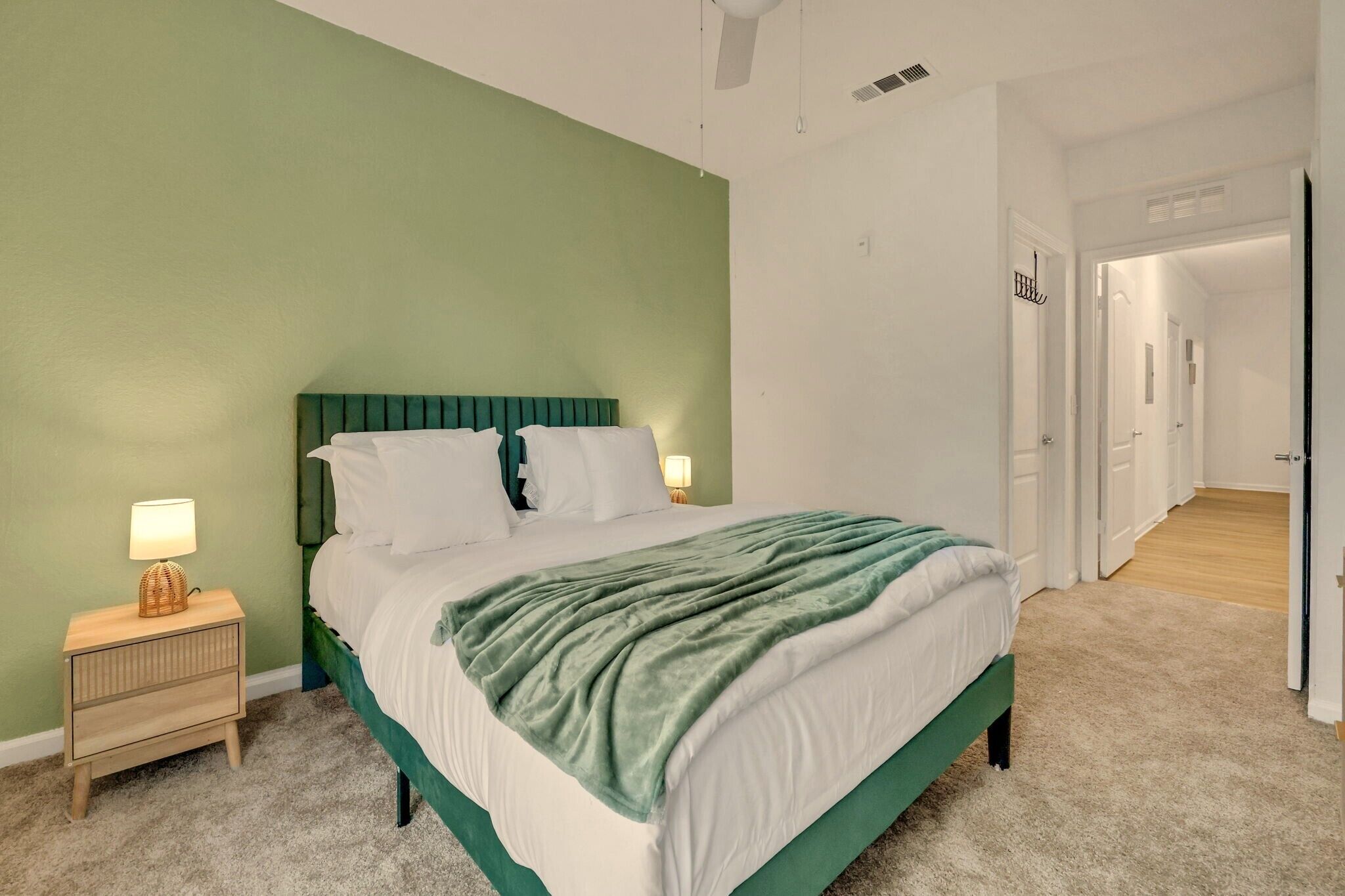 A bedroom with a bed, a bedside table, and a lamp.