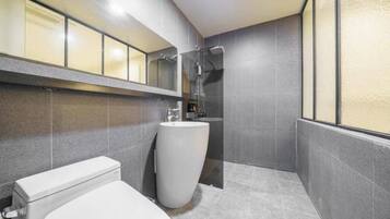 A modern bathroom with a toilet, sink, and shower.