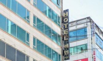 A modern building with a prominent 'HOTEL' sign, large windows, and a clean architectural design.