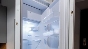 An open refrigerator with multiple shelves and a digital display. - Park Wilsona Charming Studio (Poznań)