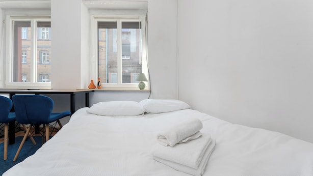 A hotel room with a bed, two windows, a desk, and a chair. - Gliwice Comfort Stay Studio (Gliwice)