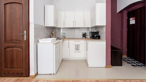 A compact kitchen with white cabinets, a small countertop, and a microwave. - Gliwice Comfort Stay Studio (Gliwice)