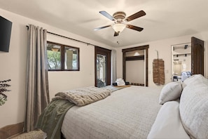 The reverse bedroom view shows the king bed, patio door, window, television, open closet and connection to the living area. - Desert Retreat - Pool, Hot Tub & Putting Green (Cave Creek)