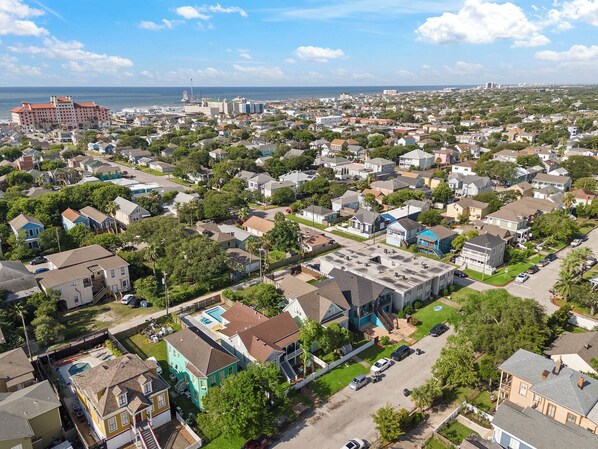 Zona residencial com casas, piscina e um prédio grande ao fundo.