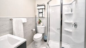 Uma casa de banho moderna com banheira, sanita e cabine de duche em vidro.