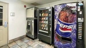 Un espace équipé de distributeurs automatiques, comprenant un distributeur de Pepsi, un distributeur d’eau fraîche et un réfrigérateur.