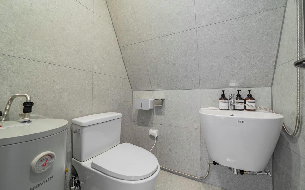 A modern bathroom with a toilet, bidet, and sink.