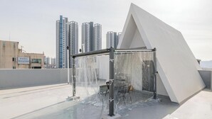 Un tetto con una grande struttura bianca, probabilmente una scultura, e un edificio sullo sfondo.