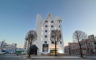 Um hotel com arquitetura única em estilo de castelo, um letreiro imponente e uma entrada visível.