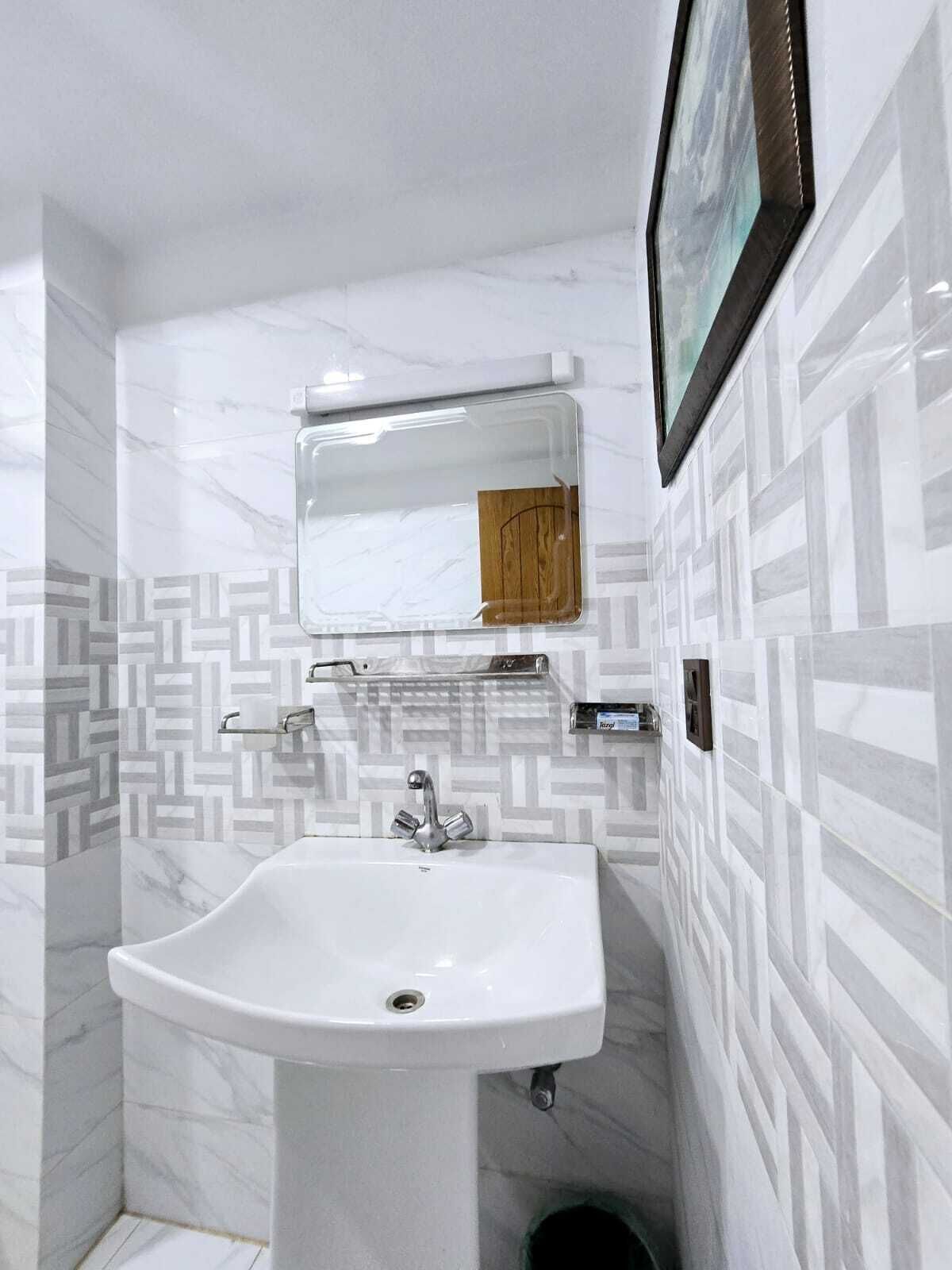 A bathroom with a white sink, a mirror, and a towel rack.