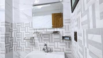 A bathroom with a white sink, a mirror, and a towel rack.