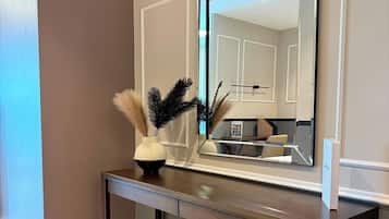 Une chambre moderne avec un grand miroir, un bureau en bois et un banc.