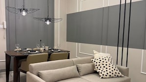 A modern living room with a sofa, dining table, and pendant lights. - Calming Blue Studio 3Pax | Bathtub | Parking (Kuala Lumpur)