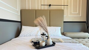 A neatly made bed with a tray of breakfast items, a bedside table, and a headboard. - Calming Blue Studio 3Pax | Bathtub | Parking (Kuala Lumpur)