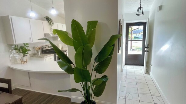 A modern kitchen with white cabinets, a central island, and pendant lighting. - Pretty lodging Serene view retreat in Lake Placid! (Lake Placid)