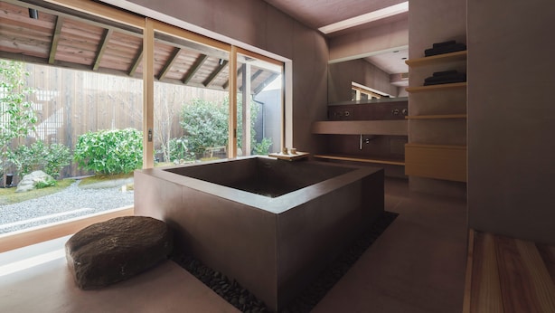 A modern bathroom with a large bathtub, wooden flooring, and a view of the outdoors. - MUDANI DARUMACHO (Kyoto)