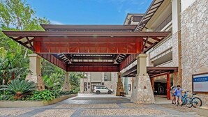 A hotel entrance with a covered walkway, stone walls, and a sign for Pullman.
