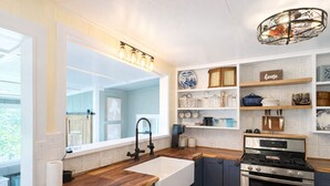 Une cuisine moderne dotée d’un grand îlot central, d’appareils électroménagers intégrés et d’un luminaire décoratif.