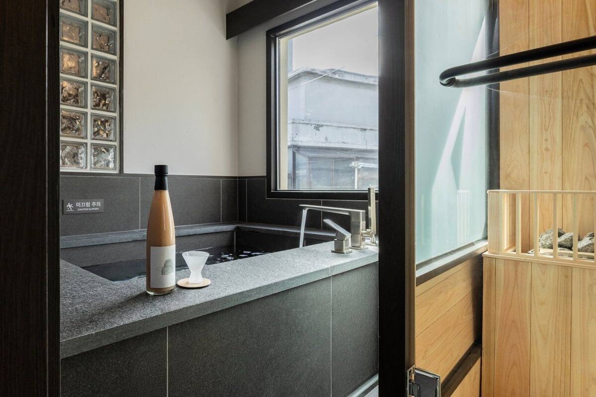 A modern kitchen with a stone countertop, a bottle, and a caution sign.