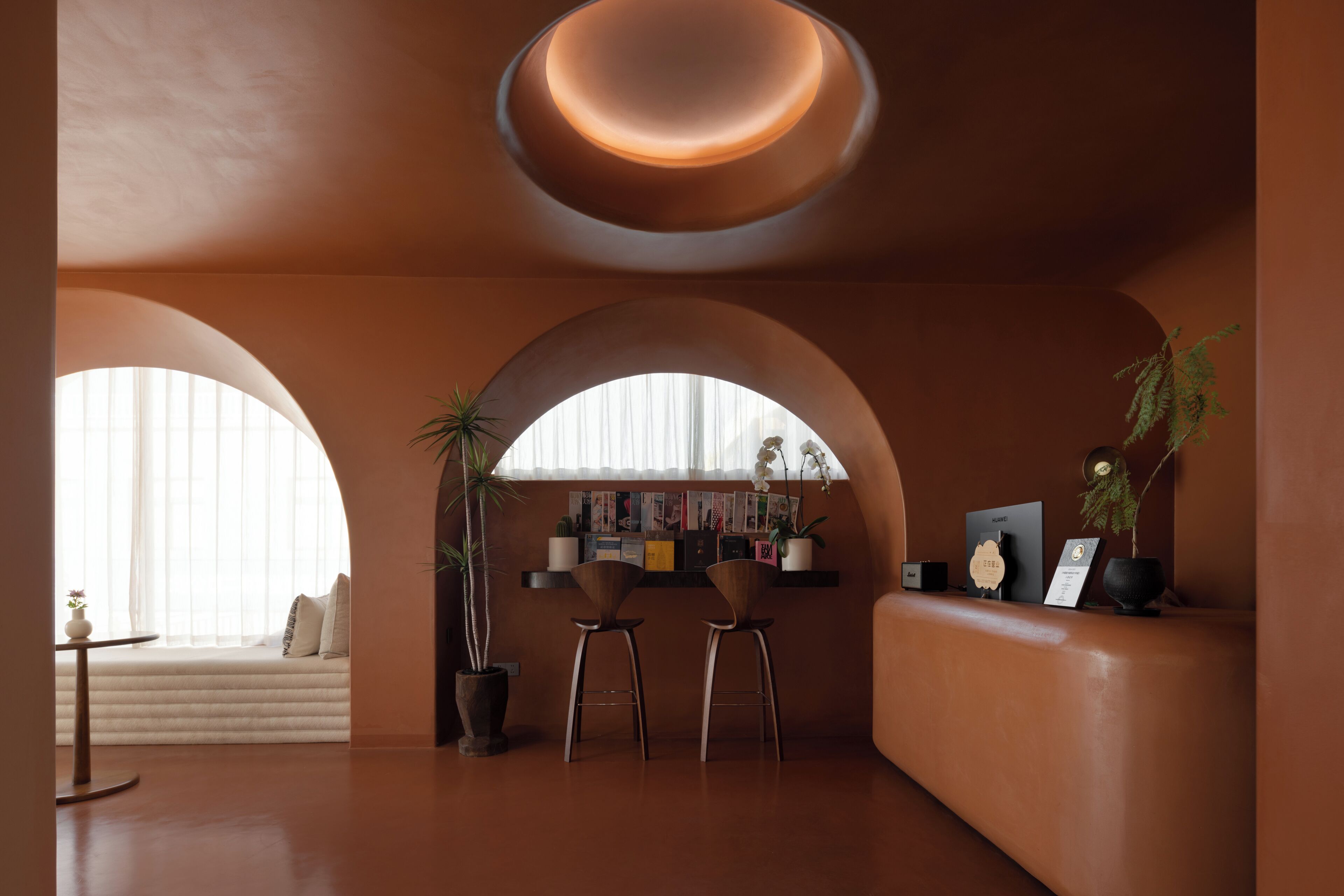 A modern interior with arched windows, a seating area, and a reception desk.