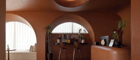 A modern interior with arched windows, a seating area, and a reception desk.