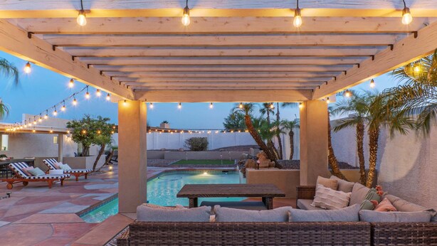 A covered outdoor area with a pool, lounge chairs, and a seating area. - Fountain Hills Splendor: One Story, Pvt Pool, Putting Green, Fire Pit, Near Hiking/Biking & Golf (Fountain Hills)
