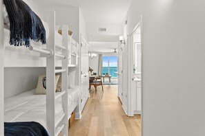 A corridor with bunk beds, a dining area, and a view of the sea. - 🌴 New Luxury Gulf-Front Escape | Fully Remodeled with Stunning Views 🌊 (Panama City Beach)