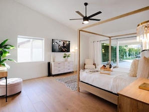 A bedroom with a four-poster bed, a ceiling fan, a TV on the wall, a window, and a plant. - Desert Springs-Pool & Spa-Near Scottsdale Quarter (Scottsdale)
