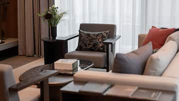 A modern living room with a sofa, armchair, coffee table, and a side table with a vase of flowers.