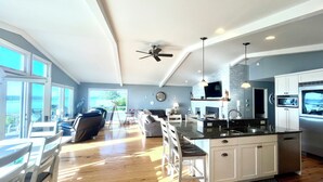 A spacious kitchen with a large island, white cabinetry, and a view of the outdoors. - Private Beach Front Executive Home (Bellingham)