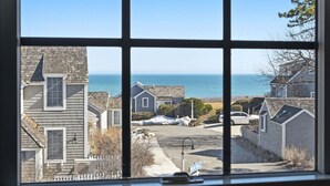 A coastal residential area with houses, a street, and a view of the sea. - Blue Tide Retreat Steps from Private Beach (Mashpee)
