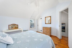 A bedroom with a bed, a dresser, a mirror, and a window. - Blue Tide Retreat Steps from Private Beach (Mashpee)