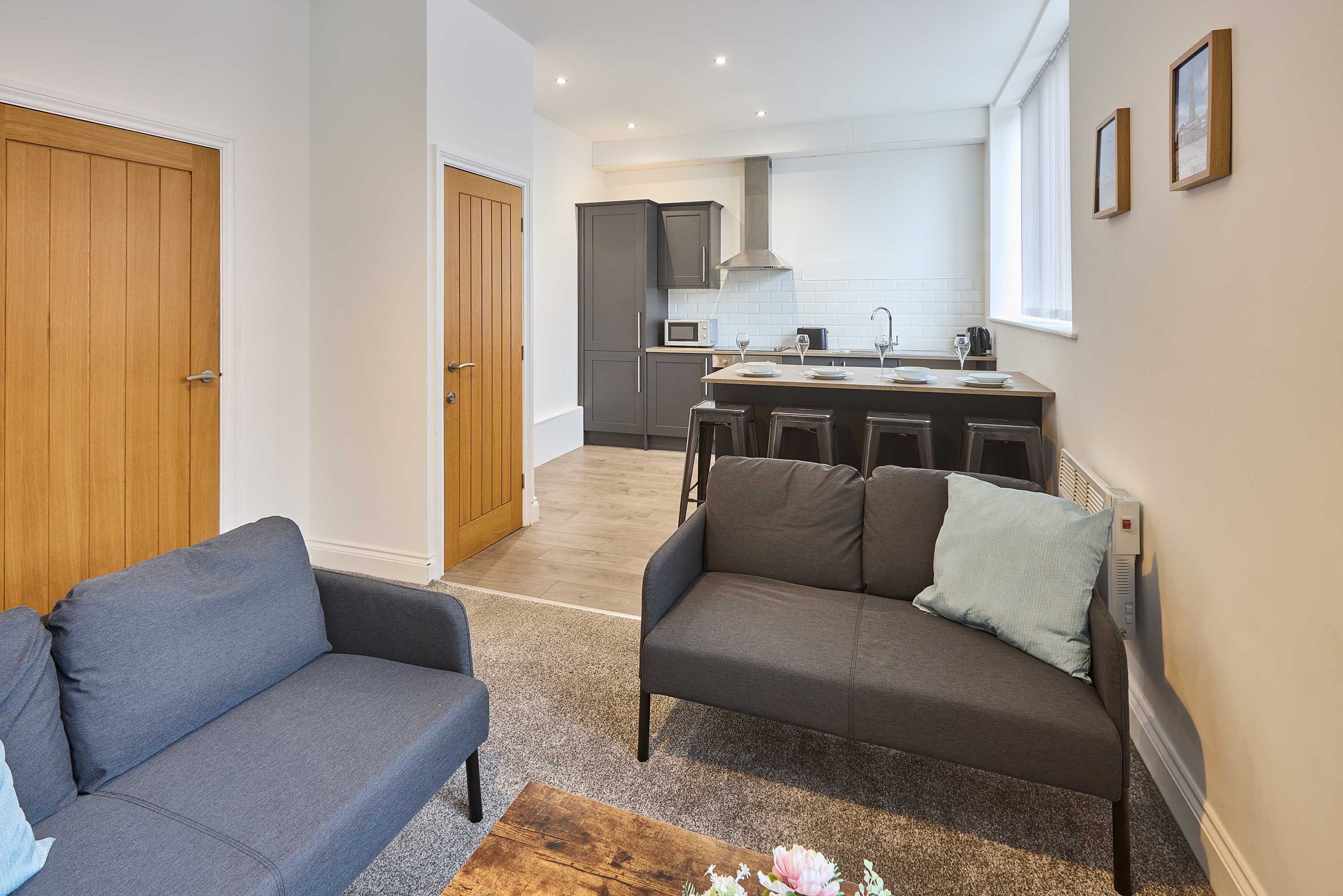 A modern apartment with a living room, a kitchen, and a dining area.