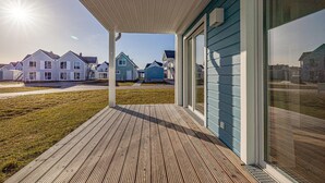 Ett bostadsområde med hus, en träterrass och en klar himmel.