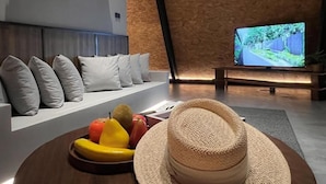 Una sala de estar moderna con un sofá, televisión y un frutero.