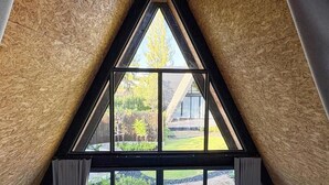 Una ventana triangular que da a un patio y un edificio.